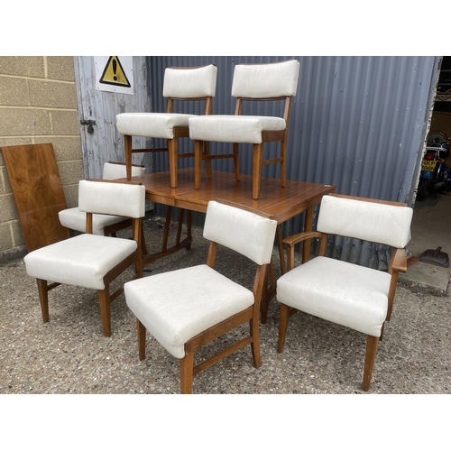 255 - A 1950' walnut extending dining table together with six chairs