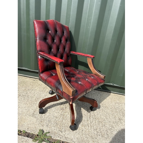 293 - An ox blood red leather chesterfield swivel office chair