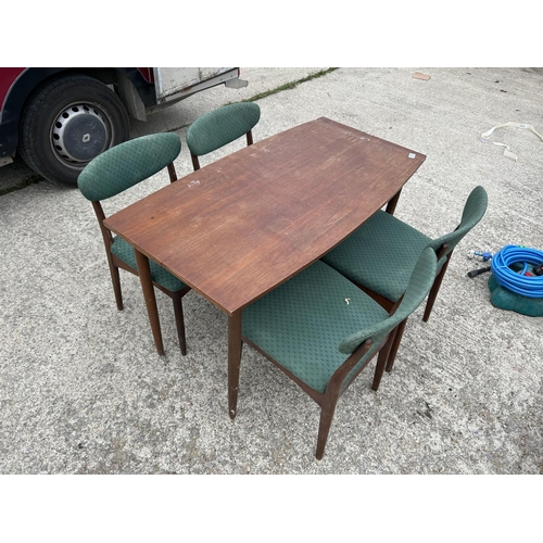 300 - A mid century teak extending dining table together with four matching chairs