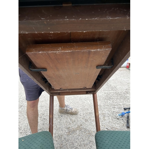 300 - A mid century teak extending dining table together with four matching chairs