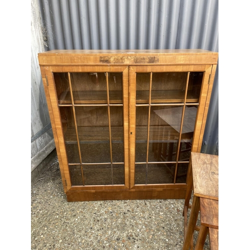 52 - A glazed walnut two door bookcase together with a walnut record cupboard and a walnut nest of three ... 