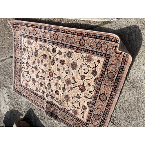 79 - A brown pattern rug together with a cream pattern rug