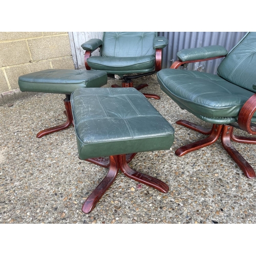 91 - A pair of green leather swivel and recline armchairs with matching footstools