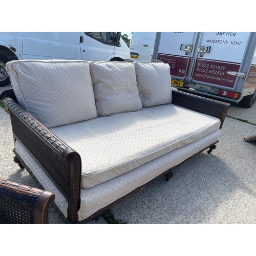 100A - An Edwardian mahogany framed begere sofa with matching armchair, loose cushions upholstered in cream... 