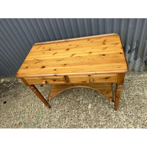 154 - A solid pine two drawer writing table