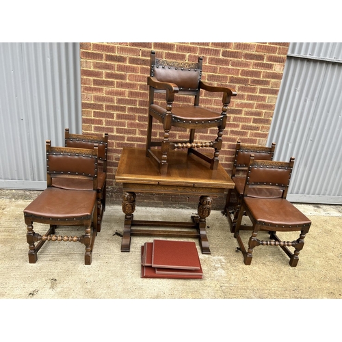 17 - An early 20th century oak drawer leaf dining table together with a set of five chairs