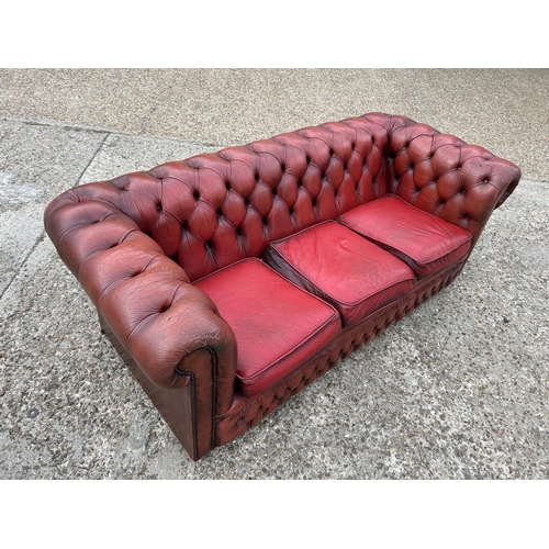 218 - A red leather three seater chesterfield sofa