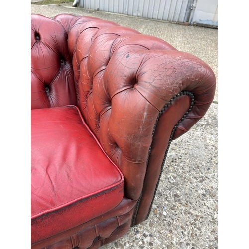 218 - A red leather three seater chesterfield sofa