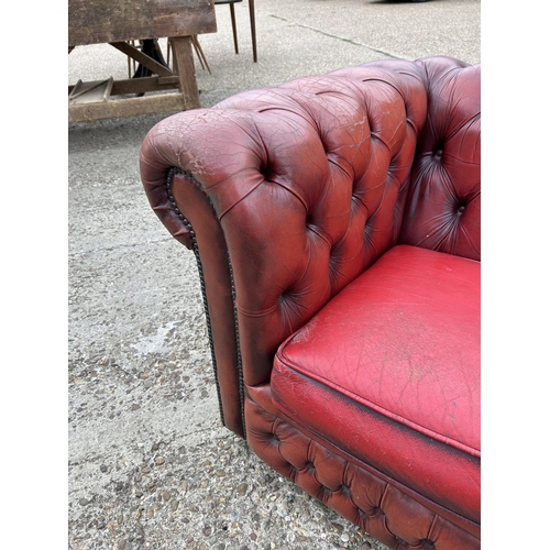 218 - A red leather three seater chesterfield sofa