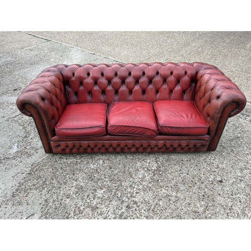 218 - A red leather three seater chesterfield sofa