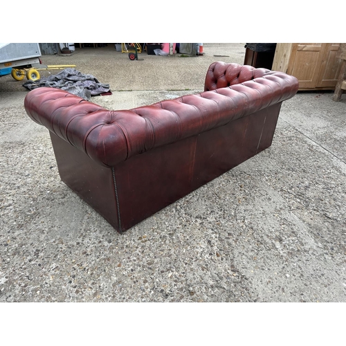 218 - A red leather three seater chesterfield sofa