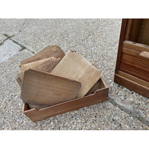 227 - A large 1920s oak three section tambour front office cupboard with all shelves (rollers appear compl... 