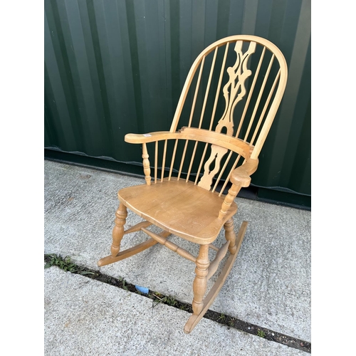 23 - A farmhouse style pine rocking chair