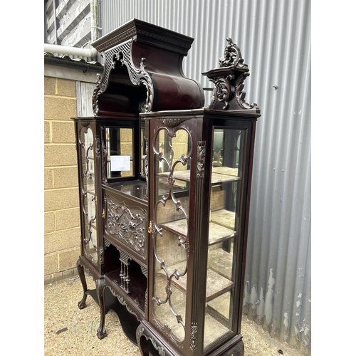 234 - A large Edwardian carved mahogany 'creeping death' cabinet, two glazed cabinet compartments, central... 