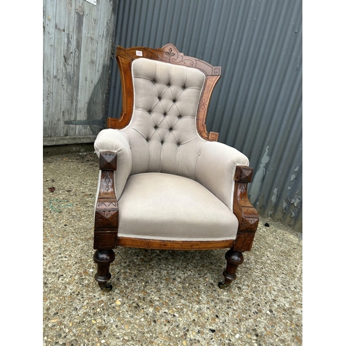 242 - A Victorian mahogany framed armchair with brown buttoned upholstery