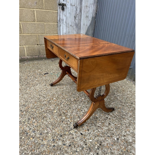 243 - A mahogany sofa table fitted with two drawers to the front and two dummy drawers to the reverse