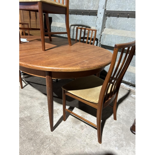 265 - A mid century oval g plan teak extending table with four chairs together