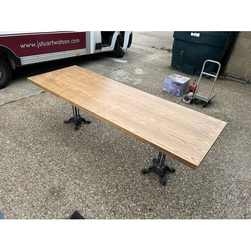 275 - A large light oak refectory table with twin  cast iron supports 240x83