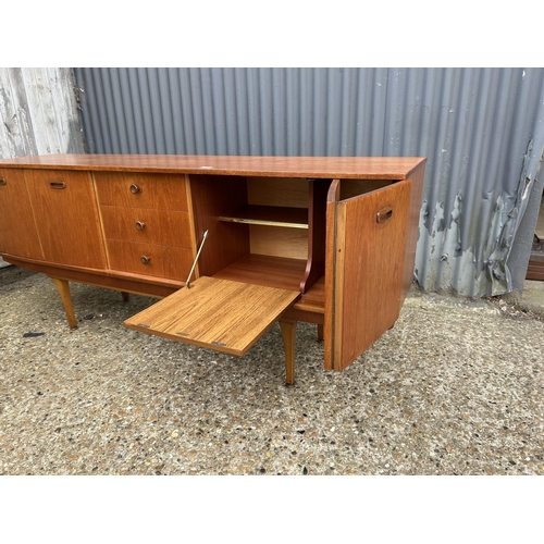 280 - A mid century teak sideboard by STONEHILL with concealed cocktail compartment