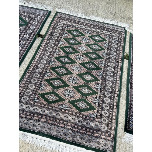 299 - A set of three green pattern rugs, largest 120x76