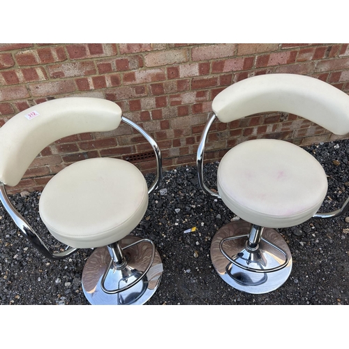 312 - A pair of modern chrome and white leather gas lift bar stools