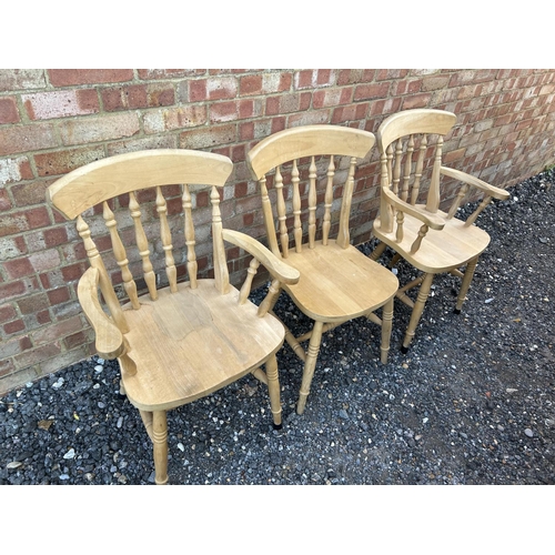 321 - A pair of pine carver chairs together with a standard chair