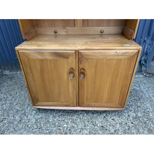 82 - A small ercol light elm dresser, open top over two door base