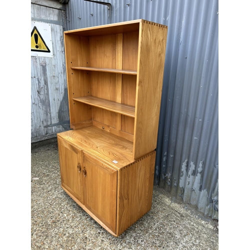 82 - A small ercol light elm dresser, open top over two door base