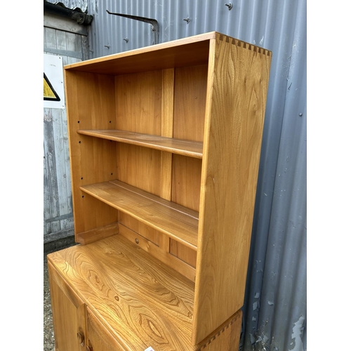 82 - A small ercol light elm dresser, open top over two door base