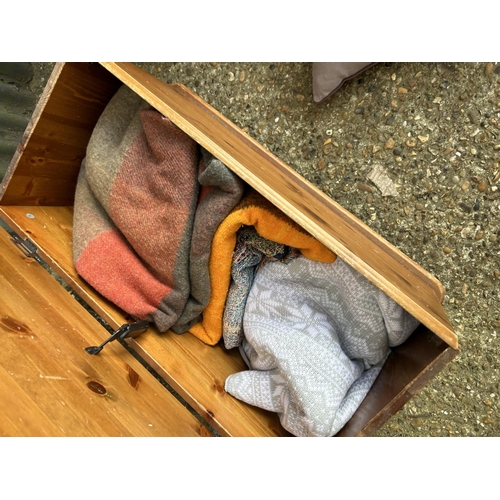 87 - Three wicker baskets, two Ralph Lauren cushions and a pine blanket box with blankets