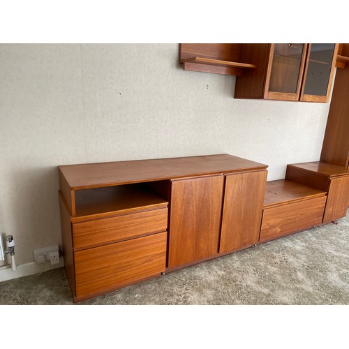 343 - A large multi section teak lounge wall system