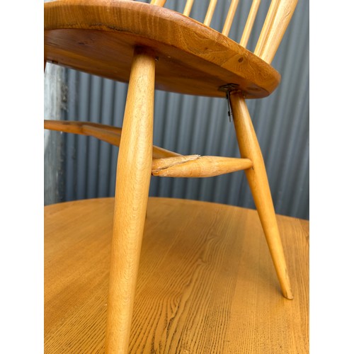 83 - An ercol light elm oval extending dining table together with four stick back chairs (one chair AF)