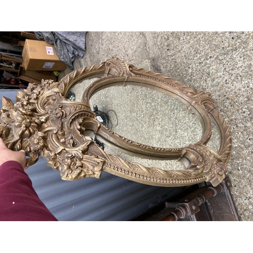 114 - A large ornate oval gold gilt wall mirror 109x145