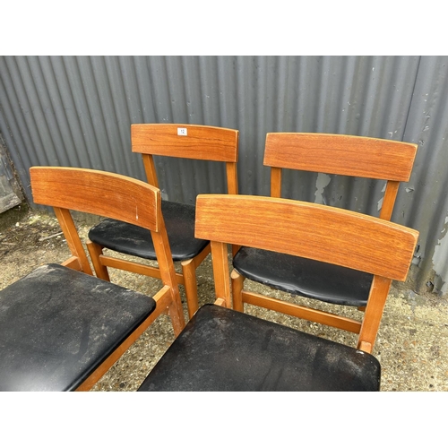 12 - A set of four teak dining chairs with black vinyl seats