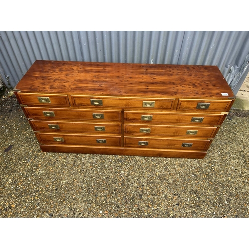 165 - A reproduction yew wood military style lowboy chest of nine drawers 150x42x70