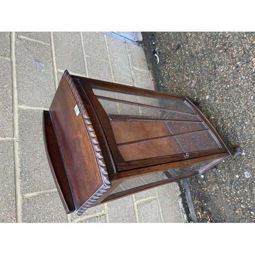 197 - A glazed oak single door cabinet with two internal shelves