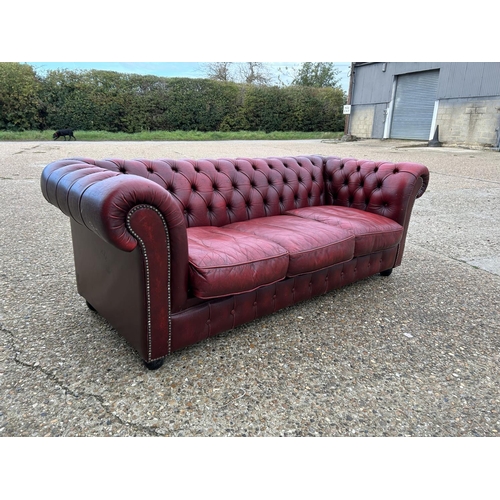 24 - A red leather chesterfield three seater sofa