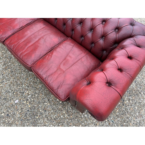 24 - A red leather chesterfield three seater sofa