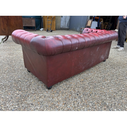 24 - A red leather chesterfield three seater sofa