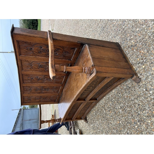 243 - A carved oak ships bench with curved  seat 136cm wide