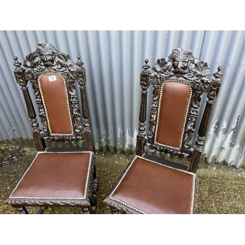 297 - A pair of carved oak chairs with leather seats