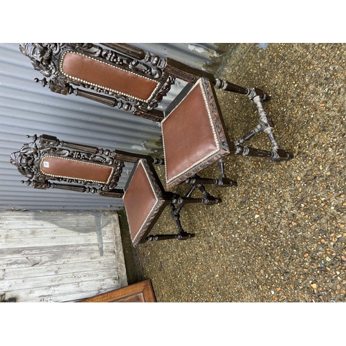 297 - A pair of carved oak chairs with leather seats