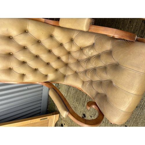 311 - A pair of gold coloured leather chesterfield slipper chairs