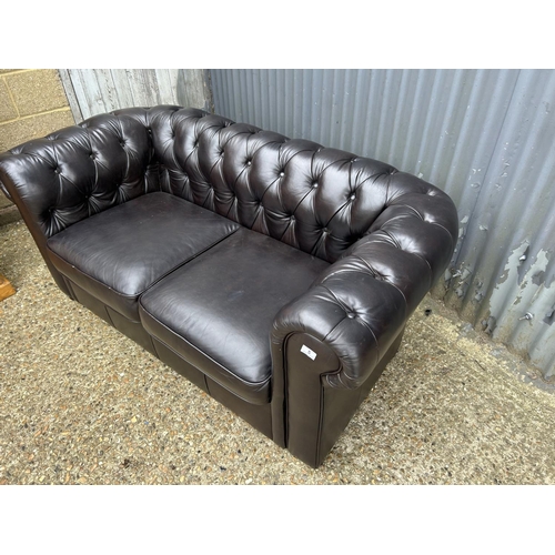 5 - A dark brown leather two seater chesterfield sofa 164cm wide