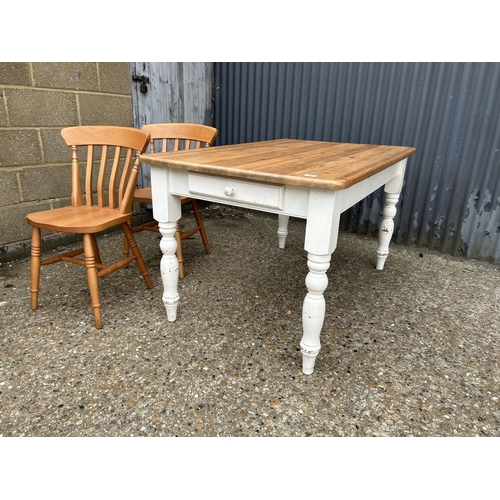 83 - A farmhouse style pine kitchen table with drawer together with two pine chairs