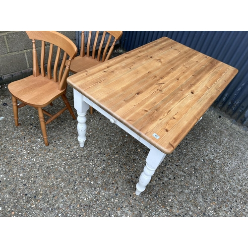 83 - A farmhouse style pine kitchen table with drawer together with two pine chairs