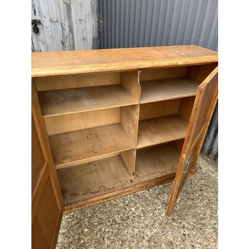 22 - A vintage two door school cupboard with partitioned interior 125x40x109