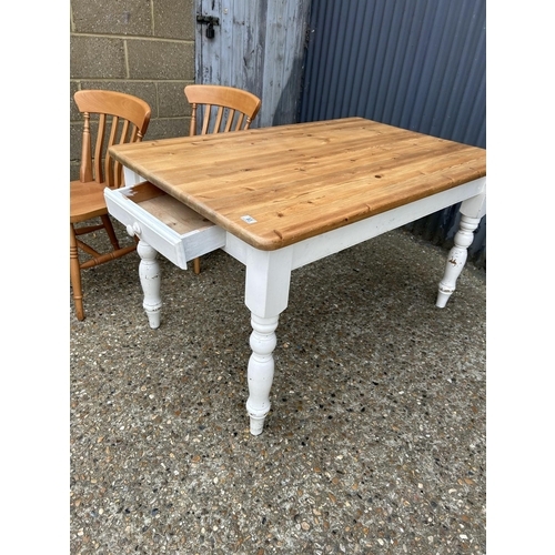 83 - A farmhouse style pine kitchen table with drawer together with two pine chairs