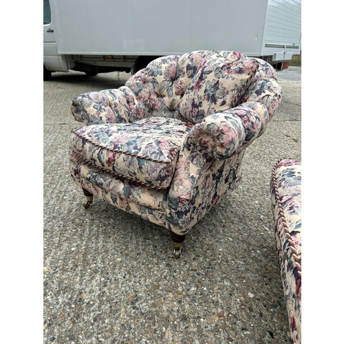 87 - A Victorian style button back sofa and armchair upholstered in a floral pattern