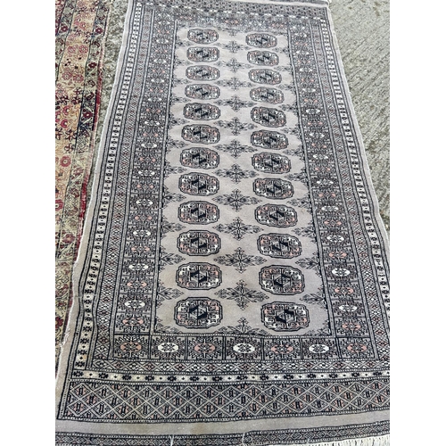 108 - Worn red and gold patterned rug together with grey pattern rug